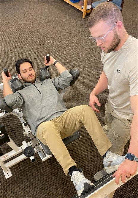 Physical therapist assisting a patient with leg presses