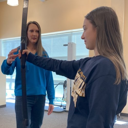 Physical therapist assisting a patient with arm and grip strength