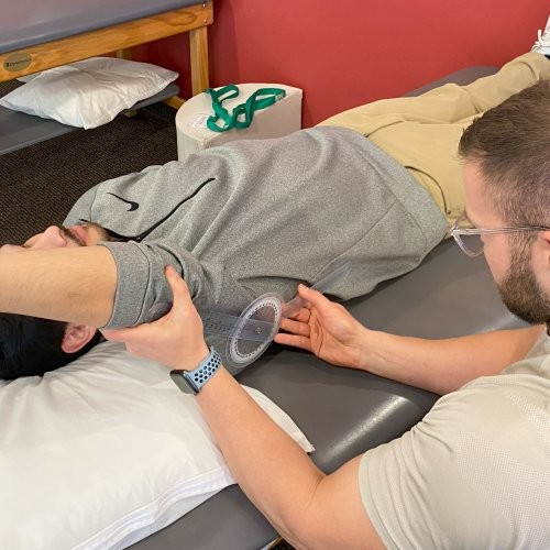 Physical therapist measuring the extension of a patient's arm